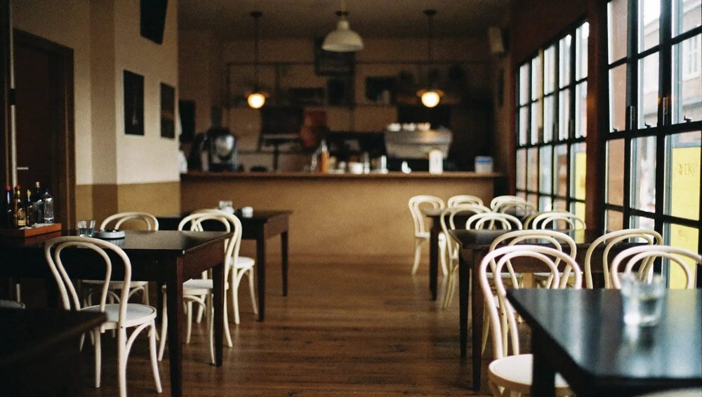 The room at The Galley: dark tables and white chairs in warm window light